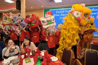 Students don lion masks to join the dragon dancers and entertain members.