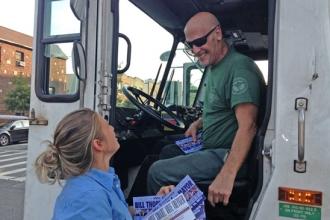 Theresa Cardazone hands literature to a city sanitation worker. 
