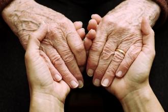 Elderly hands being held by younger hands - generic