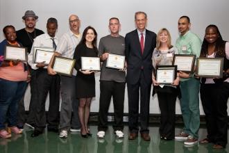 The awardees from Brooklyn with their awards and Health Commissioner Farley (fou