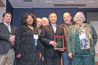 Former City Comptroller John Liu winner, holding plaque.