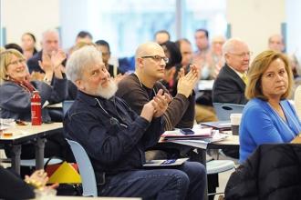 Participants applaud a conference speaker.