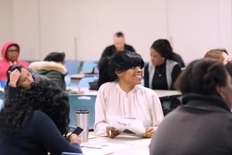 Tameka Harrison listens to INCLUDEnyc representative Jean Mizutani.
