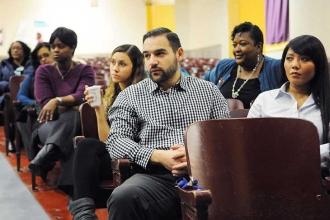Members from the four schools are engaged in the discussion.