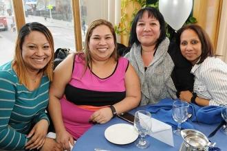 Gathered at a table decorated in UFT blue and white are PS 75 colleagues (from l