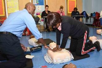 Cosmo Jackson shares his EMT skills with PS 5 teacher Joyce McIver.