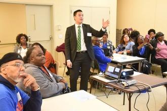 Workshop presenter Scott Lam (standing) talks finance at the Municipal Credit Un