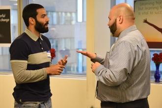 Gubran Mansour (left), a lead teacher assistant at PS 503 in Brooklyn, speaks wi