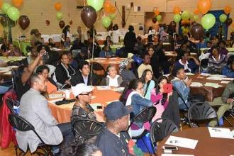Parents listen to speakers in the festively decorated lunchroom.