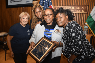 Ladies pose with plaque