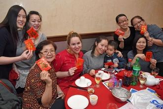 Staff and family members from PS 94 in Sunset Park, Brooklyn hold the red envelo