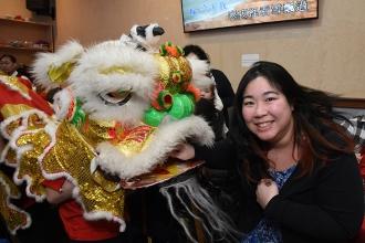 Eileen Lew, a teacher at PS 42 in Chinatown, “feeds” the lion with a money envel