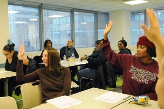 Room of students, some raising their hands