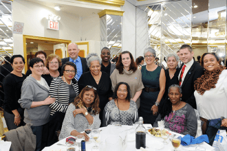 UFT President Michael Mulgrew poses with staff members from PS 33 in Queens Vill