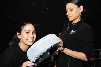 A teacher prepares for chair massage treatment from a Massage Envy practitioner.