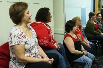 Teachers and staff listen as Mulgrew explains the governor's plan.