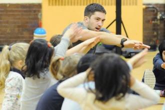 John DiGiglio leads pre-K students through a series of stretches at PS 110.