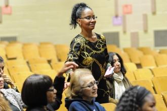 A person stands in an auditorium to ask a question