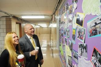 Mulgrew checks out the Bike Club bulletin board on a school tour with teacher Al