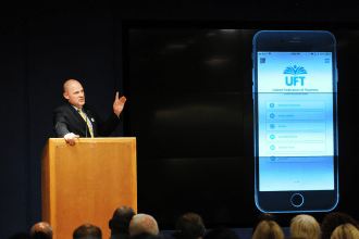 Mulgrew at podium introduces the UFT app.