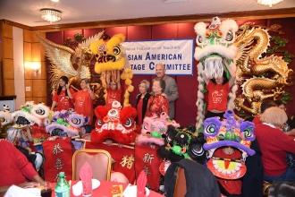Four ladies, a child, and man pose in front of elaborate puppets