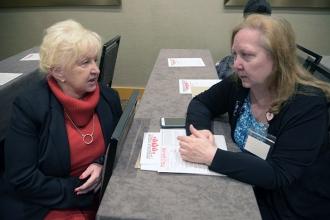 Two women, seated, talking
