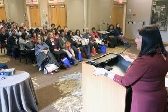 Woman at podium addressing large group