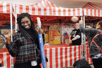 Woman standing in front of popcorn standing with a UFT umbrella