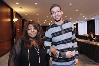 Man and women pose for camera with locked arms