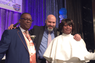 Two men and a woman pose for camera