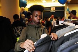 A pin-striped charcoal grey suit has this young man’s attention. 