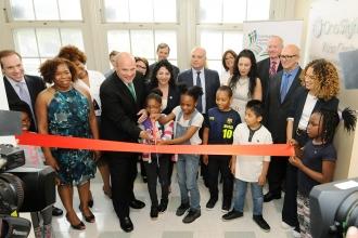 UFT President Michael Mulgrew (front, center) helps PS 188 students cut the ribb
