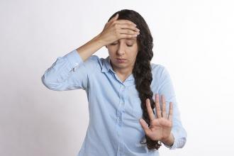 Stressed women with hand on head and gesturing stop