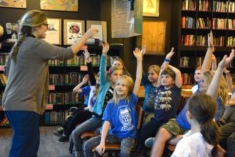 Students eagerly share their ideas for the class story.