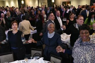 The crowd joins hands to sing the old union anthem, “Solidarity Forever.”