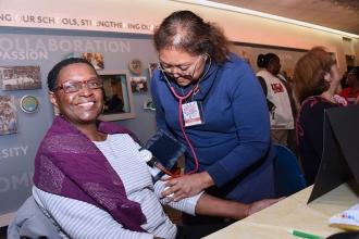 Maria Cruz takes the blood pressure of Diane Owens