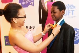 Ruth Aquino helps PS 189, Brooklyn, schoolmate Zimron Holder adjust his tie at t