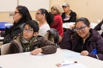 Mother Rafaela Gutierrez and son Christopher, age 11, listen to Caroline Davis p