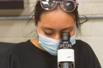 Woman looking through a lensometer