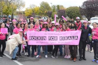 Group of people holding a banner that says Rockin for Rikala