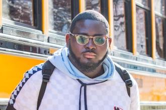 Man standing in front of yellow busses