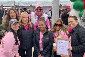 A group of marchers wearing pink pose for a photo