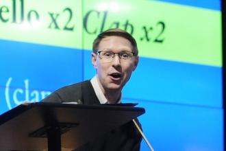 A man on stage sings and plays guitar 