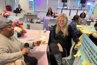 Two women at a table discuss questions