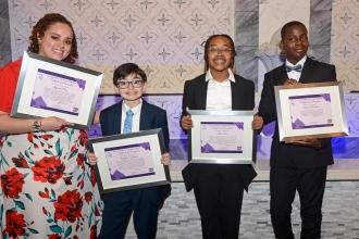 Students who received scholarship awards hold their plaques. 