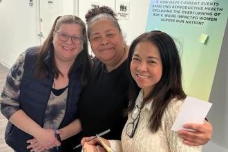 Three women pose for a photo