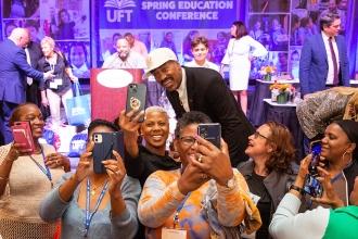 A man poses for a selfie with a group of attendees