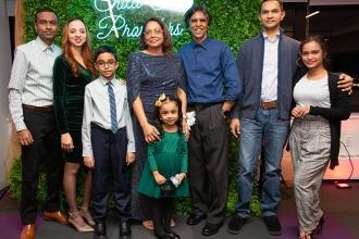 A family poses for a photo in front of a backdrop