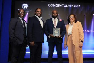 Teacher Alain Codio (second from right) of Brooklyn’s Williamsburg HS for Architecture and Design is congratulated by UFT Vice President for CTE High Schools Leo Gordon (second from left) after being named the Stanley Schair CTE Teacher of the Year during the UFT CTE Awards on Feb. 12, 2026. 