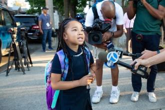 A student is interviewed by television reporters